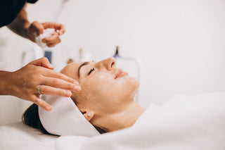 Woman receiving a facial treatment with a professional in a clinical setting.