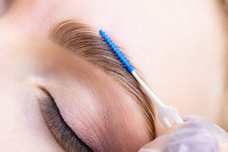 Close-up of a person receiving a brow lamination treatment, with a focus on the eye and eyebrow area.