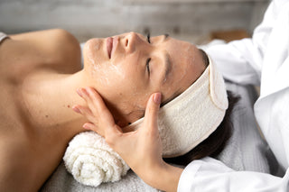 A person receiving a facial treatment, with a focus on a hydrating mask being applied to the face.