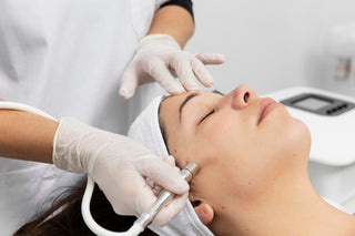 A person receiving a microdermabrasion treatment on their face, where a professional is using a handheld device on the client's skin.
